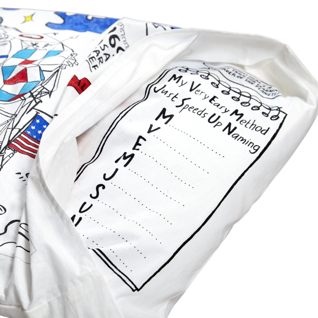 Détail d’un tissu blanc plié avec une carte colorée et des indications géographiques